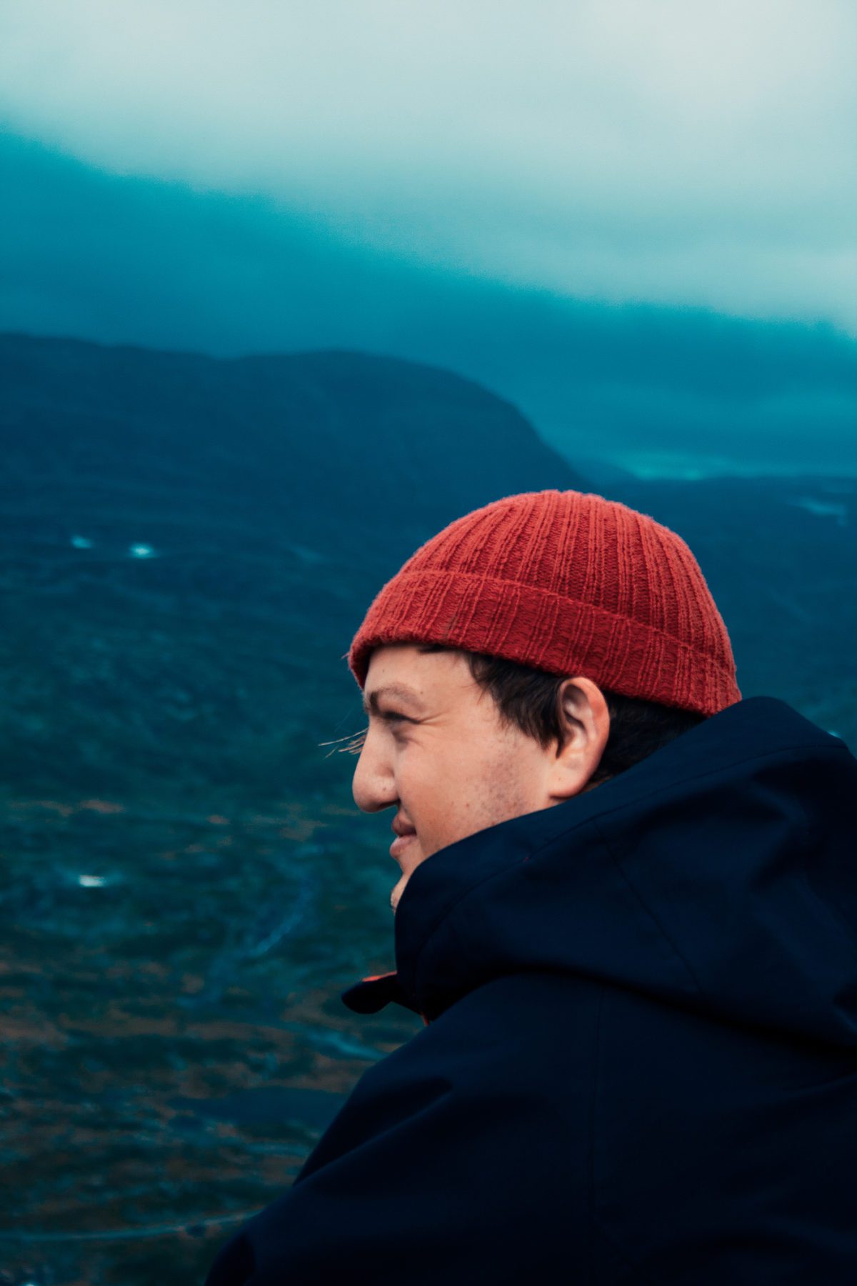 Cloudy summer mountains in Norway, man wearing beanie.