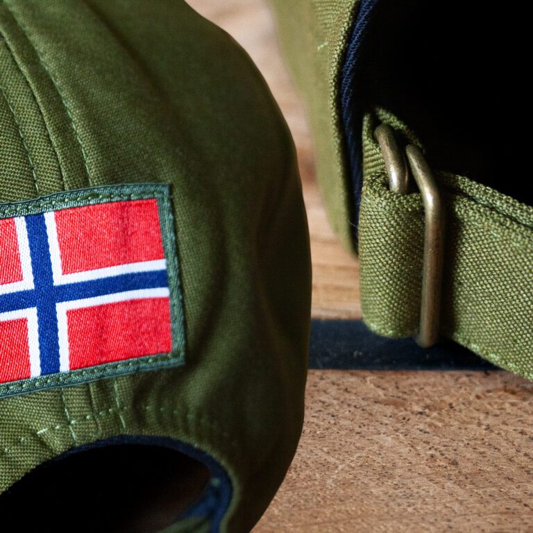 Hand knit cotton caps details. Norwegian flag and burnished metal.